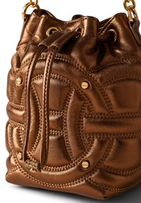 Bronze metallic pouch bag with quilted texture, gold hardware accents, drawstring closure, and circular pattern detailing on the surface.