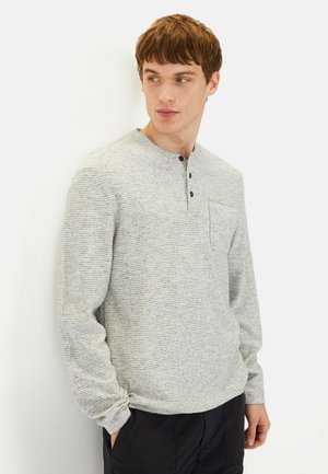 Lys grå langærmet skjorte med et tekstureret, stribet design, der har en henley-krave, tre knapper og en brystlomme.