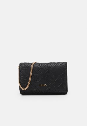 Cartera negra texturizada con patrón en relieve, correa de cadena dorada y logotipo de la marca en dorado. Forma rectangular compacta, material de cuero liso.