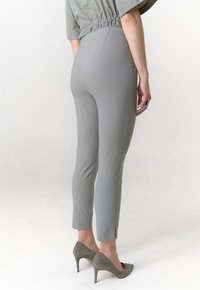 Grijze op maat gemaakte broek met taps toelopende pasvorm, gemaakt van een gladde stof, enkelhoogte en subtiele zijsplitten bij de zoom.