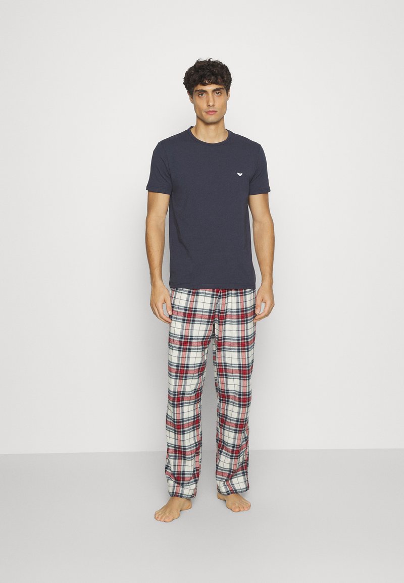 Navy cotton t-shirt with a small logo, paired with red, black, and white plaid flannel pajama pants. Soft texture, relaxed fit.