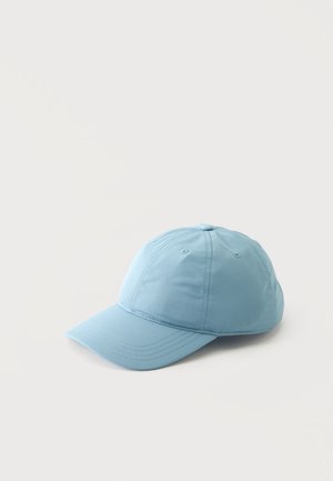 Gorra de béisbol azul claro con paneles cosidos y agujeros de ventilación, colocada sobre un fondo claro y liso.