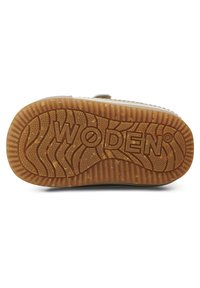 Hnedá gumová podrážka obuvi s textúrovaným vzorom, obsahujúca vlny a hrboly, s embosovaným nápisom "WODEN" v strede.
