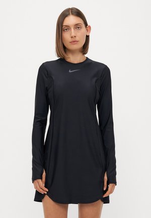 Černé sportovní šaty s dlouhými rukávy, vyrobené z hladkého materiálu. Mají kulatý výstřih a malé šedé logo Nike na hrudi.
