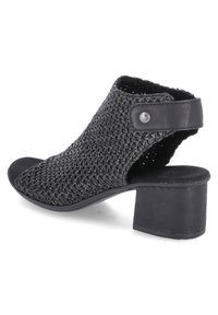 Chaussure noire à bout ouvert avec une tige en textile tissé, un accent en cuir et un talon épais. Présente un détail à pression sur le côté.