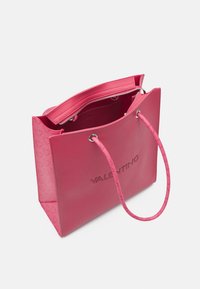 Růžová taška Valentino s embosovaným logem, dvojitými lanovými ušima a zipovou vnitřní kapsou na bílém pozadí.