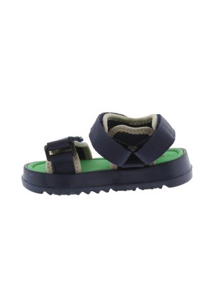 Sandalia infantil de color azul marino con correas ajustables, plantilla verde y suela negra robusta, mostrada de lado sobre fondo blanco.