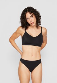 Black lingerie set featuring a v-neck bralette with adjustable straps and matching high-cut briefs, made from smooth, stretchy fabric.