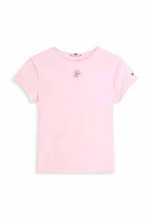 T-shirt manches courtes rose pâle avec logo rouge "TH" sur la poitrine et petit drapeau Tommy Hilfiger sur la manche gauche.