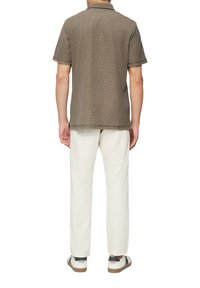 Kurzärmeliges, braun gemustertes Polohemd, kombiniert mit weißen Hosen und Freizeit Schuhen, mit geradem Schnitt und strukturiertem Stoff.