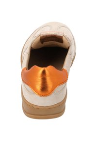 Beige mockakänga med metallisk orange accent vid hälen och tan sula; har en slät yta med scallopdetaljer.
