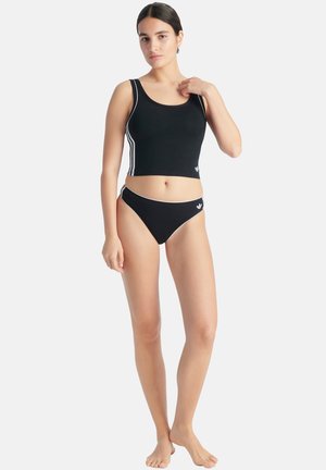 Svart atletisk crop top och bikini-set med vita ränder och logotyper, med en åtsittande design och slät textur.