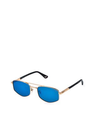 Occhiali da sole con montatura in metallo dorato, lenti rettangolari blu e aste nere curve appoggiate su una superficie bianca.