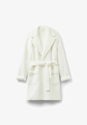 Accappatoio bianco con colletto e polsini morbidi e pelosi. Presenta una cintura da annodare e due tasche frontali. Tessuto testurizzato con strisce verticali.