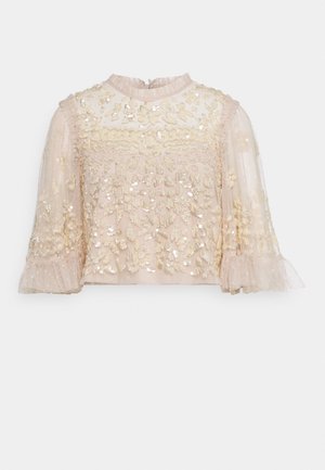 Lysebeige gennemsigtig bluse med 3/4 ærmer, blomsterblonde, palietter og volangmanchetter og halsudskæring.