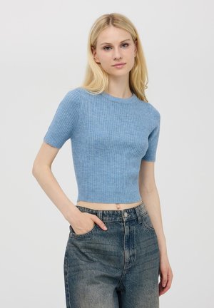 Top corto a maniche corte di colore azzurro chiaro, con scollatura rotonda. Abbinato a jeans in denim scuri a vita alta. Tessuto liscio, design aderente.