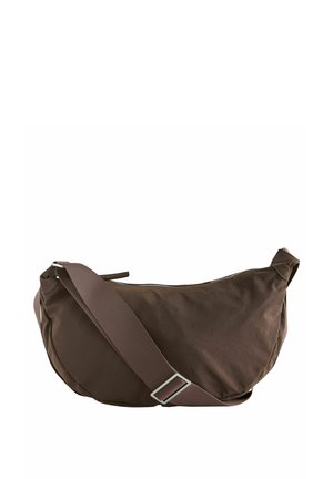 Braune Stoff-Schultertasche mit geschwungener Form, Reißverschluss und verstellbarem Gurt. Sie zeichnet sich durch eine glatte Textur und ein minimales Design ohne sichtbare Akzente aus.