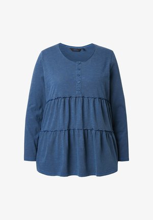 Niebieska bluzka z długim rękawem, wykonana z miękkiego materiału, z okrągłym dekoltem, listwą guzikową oraz falbaniastym, warstwowym fasonem z akcentami falbanek.