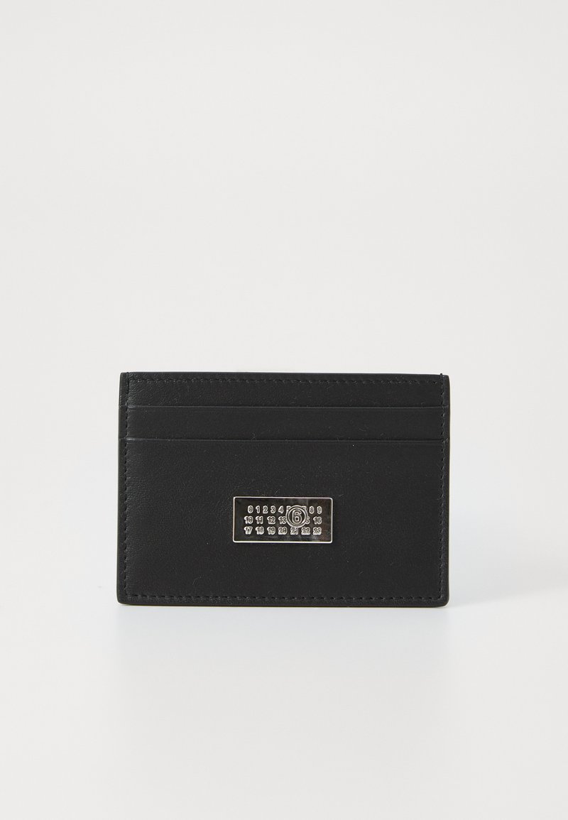 Črn usnjeni držalec za kartice z gladko teksturo, ki ima srebrno oznako in več slotov za kartice na eni strani.