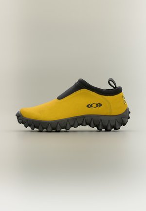 Жълта обувка без връзки с черна подметка и яка, с издръжлива подметка и малка халка на петата за лесно обуване.