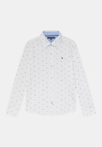 Biała koszula z długim rękawem wykonana z bawełny, z jasnoniebieskim kołnierzykiem i wzorem małych granatowych kwadratów z inicjałami "TH".