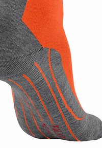 Graue Sportsocke mit orangefarbenen Akzenten und strukturierten Linien. Verfügt über eine verstärkte Zehen- und Fersenpartie für zusätzliche Haltbarkeit. Hergestellt aus einem dehnbaren, atmungsaktiven Material.