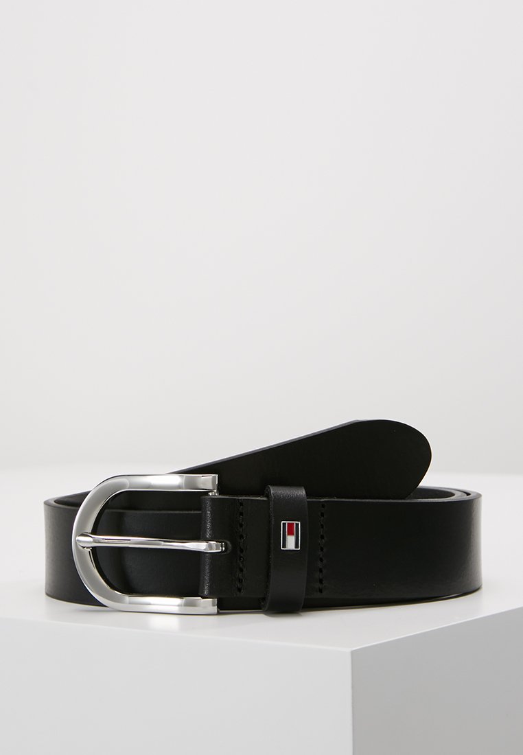 Ceinture en cuir noir avec une boucle en métal argenté, présentant un accent de logo et une texture lisse. Le design est simple et classique.