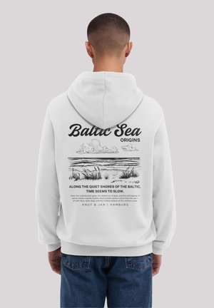 White hoodie featuring a large graphic on the back with a shoreline illustration, text, and a drawstring hood. Casual denim pants visible.