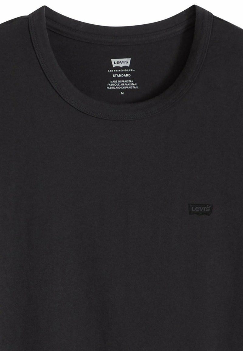 Camiseta negra Levi's de cuello redondo, talla mediana, con un pequeño parche negro sobre negro con el logo de Levi's en el pecho izquierdo.