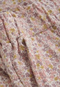 Blumenmusterstoff in Rosa, Gelb und Lila; weiche, strukturierte Baumwolle; Falten erzeugen eine geraffte Optik.