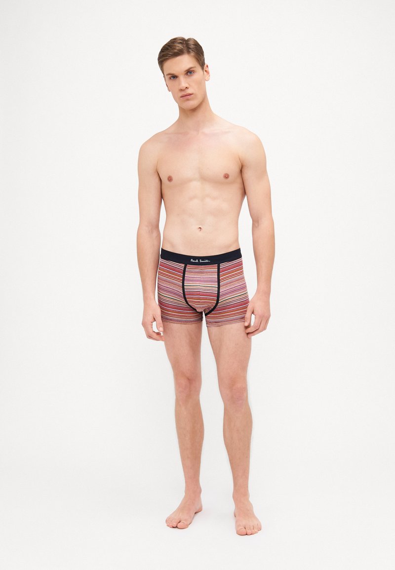 Boxer-briefs rayés en rouge, bleu marine et blanc, avec un design ajusté et une ceinture élastique, présentant un logo au centre devant.