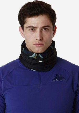 Scaldacollo a forma cilindrica, con motivo nero e verde, realizzato in materiale morbido. Indossato sopra una maglietta sportiva viola con dettagli del logo.