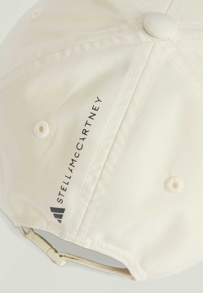 Cream-colored cap made of smooth fabric with embroidered logo text. Features button on top and adjustable strap at the back.