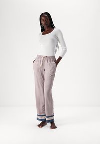 Gestreepte pyjamabroek met een elastische tailleband, in roze, blauw en witte kleuren, en een contrasterende blauwe omslag aan de onderkant.