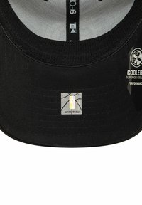 Gorra negra con visera plana. El forro interior es gris con una banda texturizada. Presenta una etiqueta del logo de la NBA en plata en la visera. Tejido fresco y de alto rendimiento.