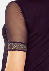 Czarna bluzka z przezroczystymi rękawami, ozdobiona koronkowym wykończeniem w kwiaty. Materiał wydaje się miękki i dopasowany w okolicy ramion.