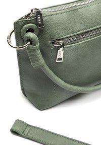 Grön läderhandväska med silverdetaljer, med ett zip-fack, sömställningar och ett rullat handtag. Avtagbar rem ingår.