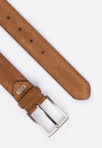 Tan ruskindsbælte med en rektangulær sølvmetalspænde, der har jævnt fordelt huller og kontrasterende syninger langs kanterne.