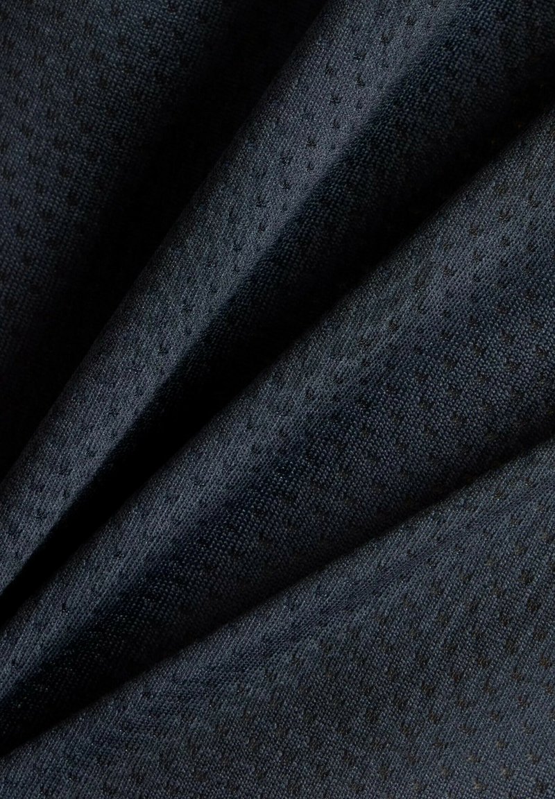 Dunkelblauer Stoff mit strukturierter Oberfläche, der ein dezentes Muster aus kleinen Punkten aufweist, die diagonal angeordnet sind.