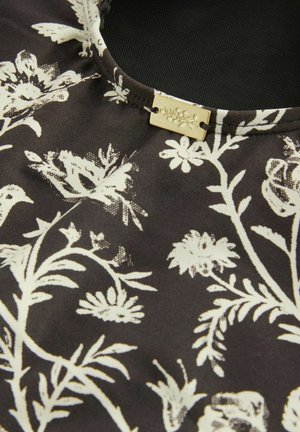 Black fabric with white floral pattern featuring leaves and flowers. Satin texture and rectangular gold-tone tag with floral engraving.