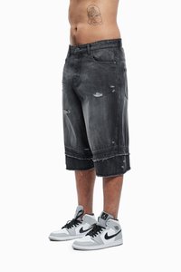 Sorte denim cargo shorts med frynser og slidte detaljer, parret med grå og hvide sneakers med sorte accenter.