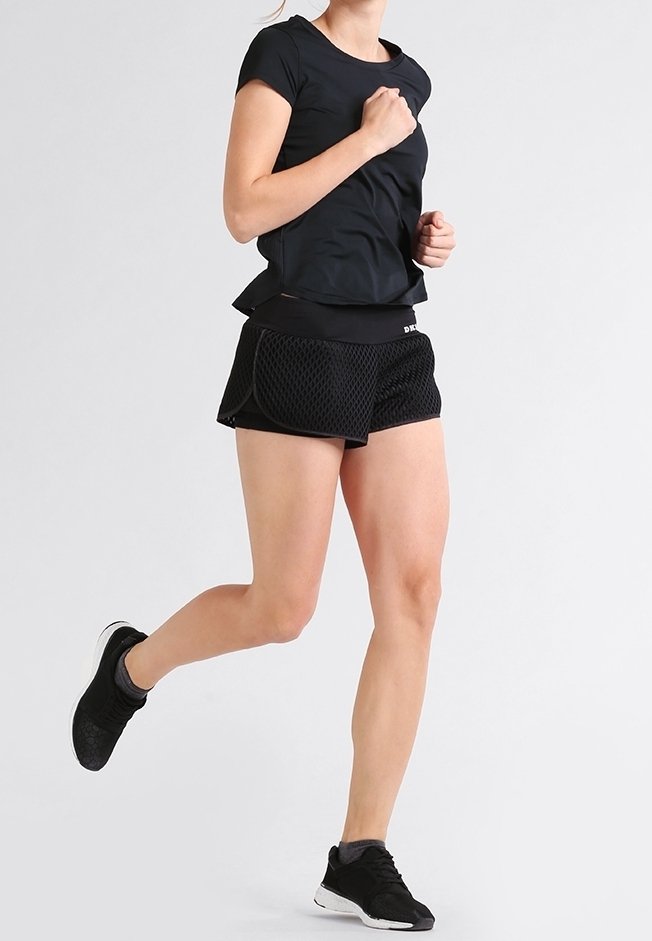 Svart atletisk t-shirt kombinerad med svarta mesh-shorts. Klädseln har en åtsittande design och ett rörligt tyg. Svarta löparskor fulländar looken.