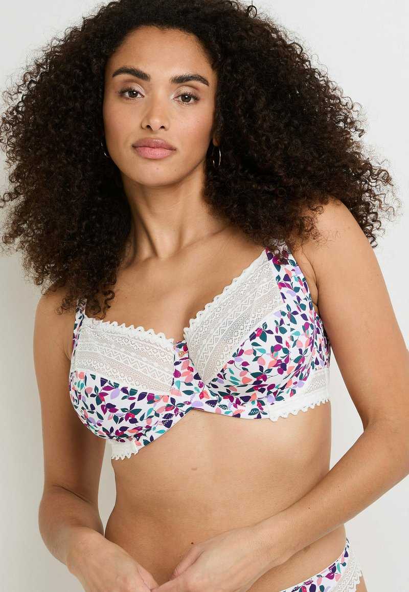 Reggiseno a fantasia floreale con bordo in pizzo bianco, caratterizzato da un mix di foglie rosa, viola e verdi su uno sfondo bianco. Spalline regolabili.