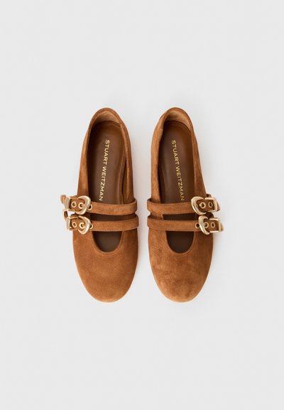 Pantofi plata din suede maro, cu vârf rotund, având două curele și accente cu catarame aurii. Căptușeală interioară netedă cu numele brandului embosat.