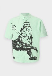 Mintgrøn kortærmet skjorte med knapper og sort pixeleret grafik af en konge, der holder en morgenstjerne, samt teksten "the new originals" nær kanten.