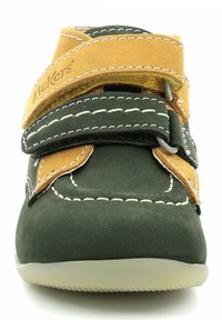 Scarpa in suede verde e beige con due cinturini in velcro, cuciture bianche, punta arrotondata e suola in gomma. Texture liscia con dettagli di cucitura visibili.