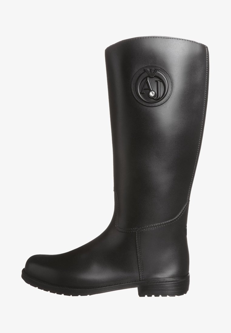 Svart gummistövlar som går upp till knäna med en rund logotypemblem, slät yta, något svängd topp och ruggad sula för bra grepp.