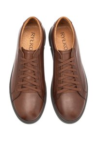 Brązowe skórzane sneakersy z zaokrąglonym noskiem, tonalnymi sznurówkami i kontrastującą gumową podeszwą. Wnętrze wyposażone jest w teksturowaną wkładkę.