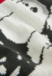 Strickpulloverstoff mit einem schwarz-weißen und grauen Muster, das eine Figur mit textilem Muster und weicher Oberfläche darstellt.