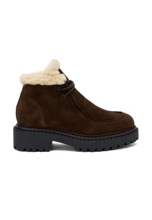 Botas de ante marrón hasta el tobillo con un cuello de piel sintética color crema, que presentan cordones negros y una suela de goma gruesa con un patrón de relieve.